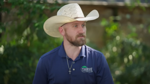 man in cowboy hat and branded polo